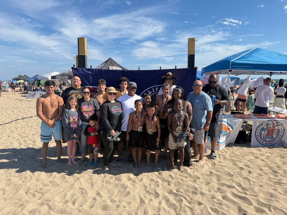 Future Champions athletes and families with medals at a beach wrestling tournament